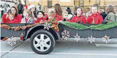  ??  ?? Students wave from the back of a float during Norman’s Christmas Parade.