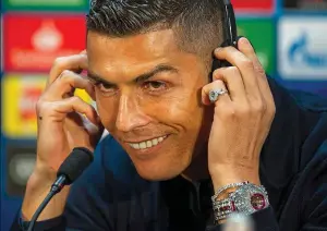  ?? EPA ?? Grin and wear it: Ronaldo is all smiles as he sports his extravagan­t timepiece and takes questions during the press conference