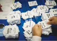  ?? (Yonatan Sindel/Flash90) ?? CENTRAL ELECTIONS COMMITTEE workers count ballots slips at the Knesset after the elections of March 2020.