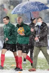  ?? GETTY ?? Spalatori in azione a Bergamo contro la neve. Sotto, l’arbitro Taylor saggia le condizioni del campo