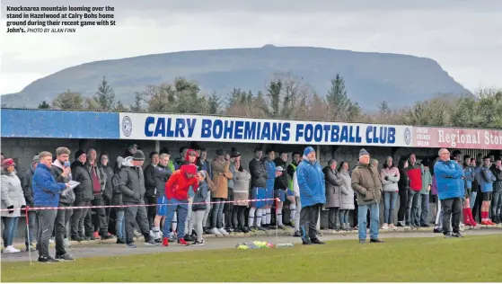  ?? PHOTO BY ALAN FINN ?? Knocknarea mountain looming over the stand in Hazelwood at Calry Bohs home ground during their recent game with St John’s.