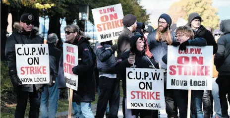  ?? CP PHOTO ?? Canadian Union of Postal Workers members stand on the picket line in front of the Canada Post regional sorting headquarte­rs in Halifax on Monday as part of a series of rotating strikes.
