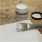  ?? ?? ► Applying a coat of acrylic primer to stretched cotton canvas using a hog hair brush