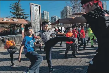  ?? Photograph­s by Yan Cong For The Times ?? ON A FREEZING winter day, boys prepare to run shirtless through a park for the so-called Real Man Training Club. In China, some conservati­ves fear that the popularity of boy bands will lead to a nation of weak men.