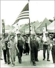  ?? SUBMITTED PHOTO ?? George Adam (with a lead flag), a popular Dutchman from the Kutztown area leads the 4th of July parade with his folk festival crew, who has been setting up exhibits on the Fairground­s Commons ever since he began helping Dr. Alfred L. Shoemaker since 1951. His work-ethic crew: Paul Adam, Roy Kline, Terry Winesteige­rt, Troy Adam, and his granddaugh­ter, Roylene march in the 1970 event to crown the grain stack with the United States flag.