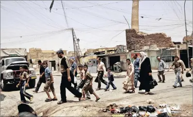  ?? PICTURE: AP ?? Residents walk past the crooked minaret next to the al-Nuri Mosque in a busy market area in Mosul in June 2009. Iraq’s ministry of defence says Islamic State militants blew up the mosque and the adjacent iconic leaning minaret.