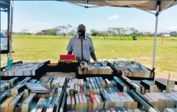  ?? ?? The community rallied to support Walter Carpenter’s second hand book business after his stock was damaged by the recent severe storms. Pictured is Carpenter at his book stall, Walter’s Books, situated opposite the Wesleyan Methodist Church in Hayfields.