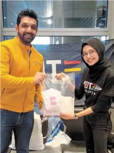  ?? ?? Mission fulfilled: dinesh handing over the 103 postal ballot papers to Siti Nazatul Nadia at Klia shortly after arriving from bangalore, india.