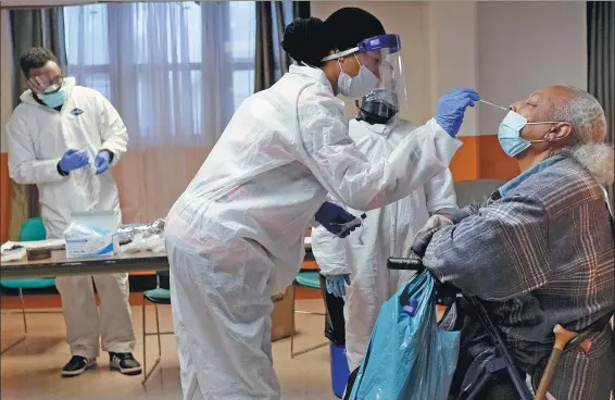  ?? ASSOCIATED PRESS ?? Left: A resident of senior housing is tested for COVID-19 in Paterson, New Jersey in May.