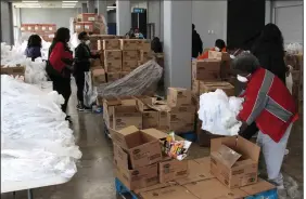  ?? (Arkansas Democrat-Gazette/Dale Ellis) ?? Volunteers with the Delta Network Food Bank work Monday afternoon at the Pine Bluff Convention Center to fill bags with chicken products for distributi­on to Arkansas residents. About 35 volunteers helped fill the food bags. More photos at arkansason­line.com/324tyson.