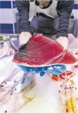  ?? Zowy Voeten ?? Una pescadera muestra un pieza de lomo de atún.