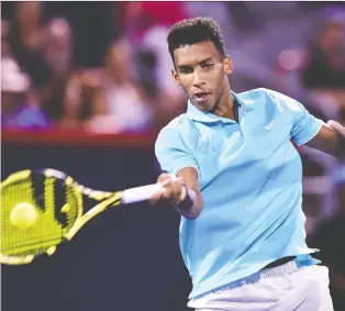  ?? MINAS PANAGIOTAK­IS/GETTY IMAGES ?? Felix Auger-aliassime volleys against Milos Raonic at the Rogers Cup in Montreal on Wednesday. Raonic retired with the match knotted at a set apiece.