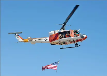  ?? Buy these photos at YumaSun.com PHOTOS BY RANDY HOEFT/YUMA SUN ?? A U.S. MARINE CORPS Search and Rescue helicopter carries an American flag as it passes over the site of Wednesday morning’s 10th anniversar­y memorial ceremony recognizin­g the crew of four that died in the crash of another SAR helicopter north of Yuma...