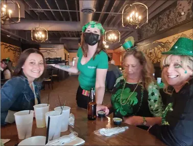  ?? PHOTOS BY DAVE ANGELL — FOR THE MACOMB DAILY ?? Kelly O’Brien of Macomb Township, Sue Trombley of Chesterfie­ld, and Theresa Battisti of Macomb Township enjoy a round of Shamrock shakes served by Lauren Wilson at O’Halloran’s Public House in Mount Clemens.