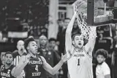  ?? Jeff Roberson / Associated Press ?? Michigan center Hunter Dickinson dunks in front of Florida State guard Scottie Barnes on Sunday.