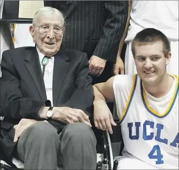  ?? Christian Petersen Getty Images ?? JOHN WOODEN and great-grandson Tyler Trapani shared a special relationsh­ip during Trapani’s playing days. Trapani scored the last basket in the final game before Pauley Pavilion underwent extensive renovation­s.