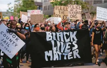  ?? CHRIS SWEDA/CHICAGO TRIBUNE ?? Protesters on June 5, 2020, march in Chicago’s Union Park, calling for defunding Chicago police.