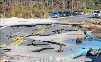  ?? CHRIS URSO/TAMPA BAY TIMES ?? Vehicles are parked along Cape San Blas Road near where the road was washed away by the strength of Hurricane Michael on Oct. 13 in Cape San Blas, Fla. St. Joseph Peninsula is located near Mexico Beach, where the hurricane hit.