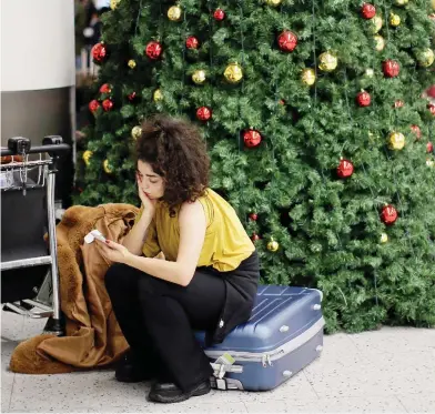  ?? TIM IRELAND / THE ASSOCIATED PRESS ?? A woman waits in the departures area at Gatwick airport, near London, on Thursday while airport operations are shut down, with incoming flights delayed or diverted to other airports, due to drone traffic over the airfield.