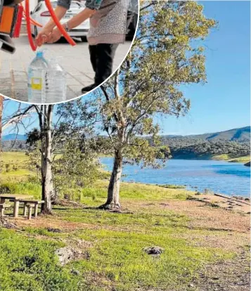  ?? // FOTOS: REUTERS/ABC ?? Una vecina de la Sierra Norte de Córdoba llena una garrafa de agua potable. Abajo, imagen del pantano de Aracena