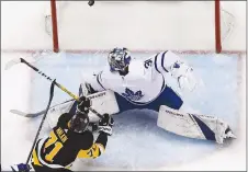  ?? CP PHOTO ?? Pittsburgh Penguins’ Evgeni Malkin puts the puck behind Toronto Maple Leafs goaltender Frederik Andersen on Saturday.