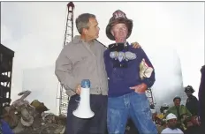  ?? DOUG MILLS/AP ?? AS RESCUE EFFORTS CONTINUE in the rubble of the World Trade Center in New York, President George W. Bush (left) stands with New York City firefighte­r Bob Beckwith on a burnt fire truck in front of the World Trade Center during a tour of the devastatio­n on Sept. 13, 2001.