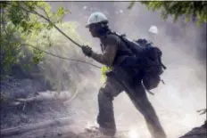  ?? KARI GREER/BLM/USDA FOREST SERVICE VIA AP ?? In this Aug. 17 photo provided by BLM/USDA Forest Service, a member of a fire crew out of Lakeview, Ore., works on the Cougar Creek Fire in central Washington state. After being in firefights in Afghanista­n and Iraq, members of the new elite crew are bringing their military experience to bear as they battle wildfires in the most rugged country back home The Lakeview Crew 7 is comprised almost entirely of U.S. military veterans.