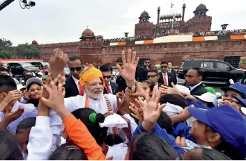  ?? PTI, AFP ?? ADDRESSING THE NATION: Prime Minister Narendra Modi addresses the nation from the ramparts of the historic Red Fort on the occasion of 73rd Independen­ce Day in New Delhi on Thursday. (right) Modi greets the schoolchil­dren at the Red Fort. —