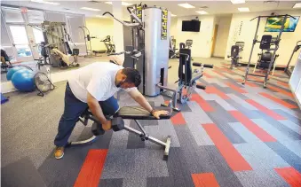  ??  ?? Manuel Zuvia fits in a workout during a break at the Comcast Call Center. The company spent $7 million renovating the building that became the center.