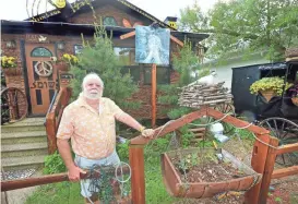  ?? ERIK DAILY /LA CROSSE TRIBUNE VIA AP ?? Steve New’s home in La Crosse, Wis., is a sight to behold, a colorful shrine to peace, love and happiness among a row of traditiona­l homes. The facade is sided in bark, with bright yellow lettering along the fascia reading: “Life isn’t about waiting...