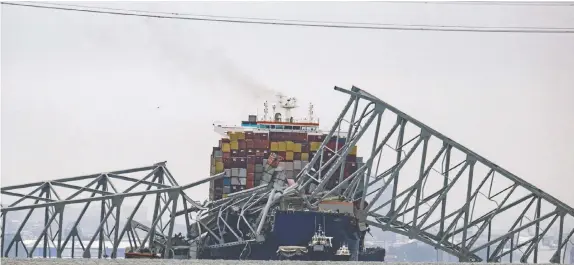  ?? JIM WATSON/AFP VIA GETTY IMAGES ?? The collapsed Francis Scott Key Bridge lies on top of the container ship Dali in Baltimore, Md., on Wednesday.