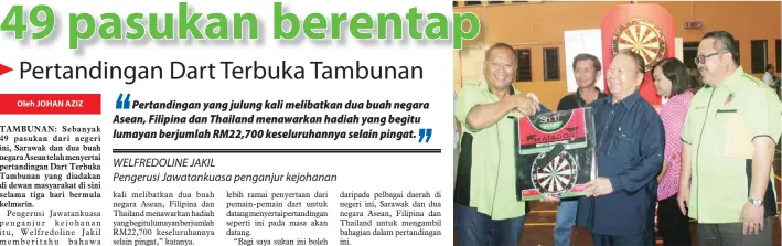  ??  ?? WILFREDOLI­NE (kiri) menyampaik­an cenderaken­angan kepada Pairin. Turut kelihatan Thomas (kanan).