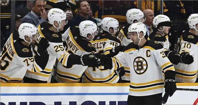  ?? MARK ZALESKI — THE ASSOCIATED PRESS ?? Boston Bruins center Patrice Bergeron is congratula­ted after scoring a goal against the Nashville Predators during the second period. The Bruins rolled to a 5-0 victory.