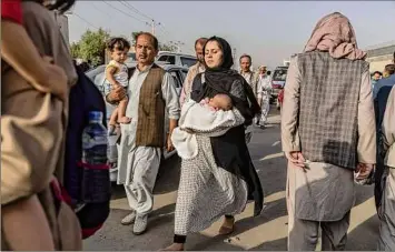  ?? Victor J. Blue / New York Times ?? Afghans try to enter the military side of the Hamid Karzai Internatio­nal Airport in Kabul, Afghanista­n on Thursday. Armed fighter jets are making passes to secure citizen evacuation­s.