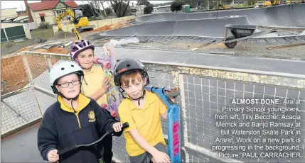  ??  ?? ALMOST DONE: Ararat Primary School youngsters, from left, Tilly Beccher, Acacia Merrick and Banjo Ramsay at Bill Waterston Skate Park in Ararat. Work on a new park is progressin­g in the background. Picture: PAUL CARRACHER