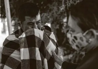  ??  ?? A Guatemalan migrant is comforted in Sasabe, Mexico, after the Border Patrol released him. Intercepti­ons of migrants entering the U.S. illegally along the Arizona-Mexico border are rising.