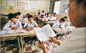  ?? PHA LINA ?? A teacher guides students through an academic exercise in her classroom at Phnom Penh’s Wat Koh High School in 2014.