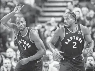  ?? CP PHOTO ?? Toronto Raptors forward Serge Ibaka (9) celebrates a basket against the Charlotte Hornets with teammate Kawhi Leonard (2) during first half NBA basketball action in Toronto on Monday.