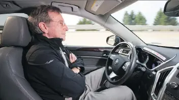  ?? JOHN F. MARTIN/FOR CADILLAC ?? General Motors staff researcher Jeremy Salinger tests a self-driving vehicle. Transporta­tion planners predict such vehicles will be regular features on local roads in 15 years.