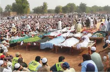  ?? AFP ?? Relatives and local residents prepare to offer funeral prayers for the victims of the bus accident in Kohat district in Khyber Pakhtunkhw­a province yesterday.