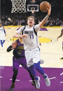  ?? Mark J. Terrill / Associated Press ?? Mavericks rookie Luka Doncic, shown driving past Lakers forward Kyle Kuzma on Friday, is averaging 18.4 points.