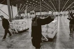  ?? Pool / Getty Images ?? Boxes containing the Moderna COVID-19 vaccine are prepared to be shipped at the McKesson distributi­on center in Olive Branch, Miss.