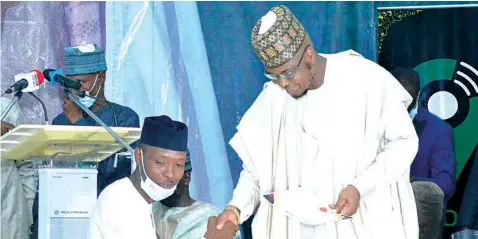  ??  ?? Minister of Communicat­ions and Digital Economy, Dr. Isa Pantami ( right) presenting a certificat­e to one of the participan­ts at the 9mobile Digital Skills Entreprene­urship Programme for Youths, Usman Aliyu, during the graduation ceremony at Bichi Emirate Council, Kano State… yesterday