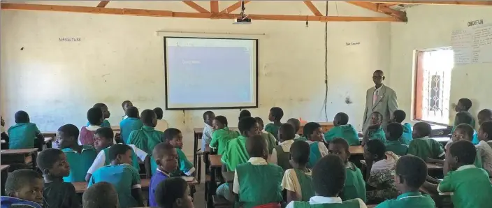  ?? PROVIDED TO CHINA DAILY ?? A teacher at Kuputu Primary School in Salima Town, Malawi, uses a projector provided by Li Shangyi’s company, StarTimes.