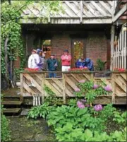  ??  ?? Pictured in the center of his back deck in the red jacket is Rensselaer County legislator Peter Grimm, who serves as president of the Friends of Prospect Park, the volunteer group that organizes the Hidden Garden Tour, as he talks to some guests in his...