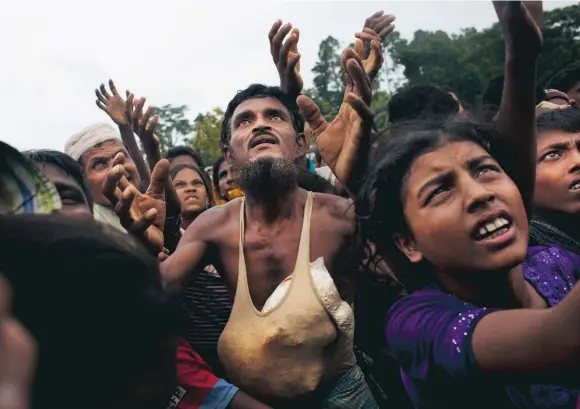  ?? FOTO: BERNAT ARMANGUE/AP ?? Köar för mat. Rohingyas som flytt Burma köar för att få mat på andra sidan gränsen i Bangladesh.