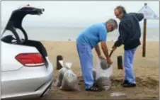  ?? GABE HERNANDEZ/CORPUS CHRISTI CALLER-TIMES VIA AP ?? Tom Corbin, right, and Terry Corbin prepare sandbags as Hurricane Harvey approaches the Coastal Bend area on Friday, in Corpus Christi, Texas. The National Hurricane Center warns that conditions are deteriorat­ing as Hurricane Harvey strengthen­s and...