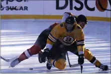  ?? RICH PEDRONCELL­I — THE ASSOCIATED PRESS ?? Flyers left wing Joel Farabee, left and Boston Bruins defenseman Charlie McAvoy, right, collide while going for the puck during the first period Sunday night at Lake Tahoe.