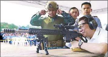  ??  ?? President Duterte fires several rounds from a sniper rifle as he leads the ceremonial shoot during the opening ceremony of the National Special Weapons and Tactics Challenge at the Team Davao Inc. Pistol and Rifle Range in Ma-a, Davao City the other...