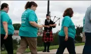  ?? Diane Wagner / Rome News-Tribune ?? Bagpiper Tyler Lembcke plays as cancer survivors, their families and supporters cross onto the pedestrian bridge.